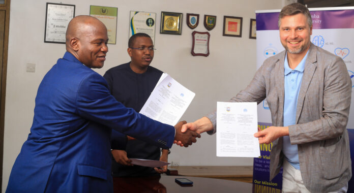 Prof. Jude exchanging a copy of the MoU with Mr. Mansur M as His Worship Fabrice Rulinda Keenly watches