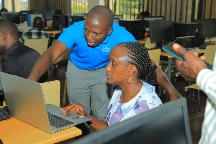 Cyber School Official Vicent Kiseka guides Dr. Anne Abaho, Dean School of Social Sciences during the training