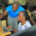 Cyber School Official Vicent Kiseka guides Dr. Anne Abaho, Dean School of Social Sciences during the training